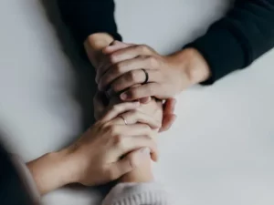 Mains enlacées en signe de soutien et de réconfort